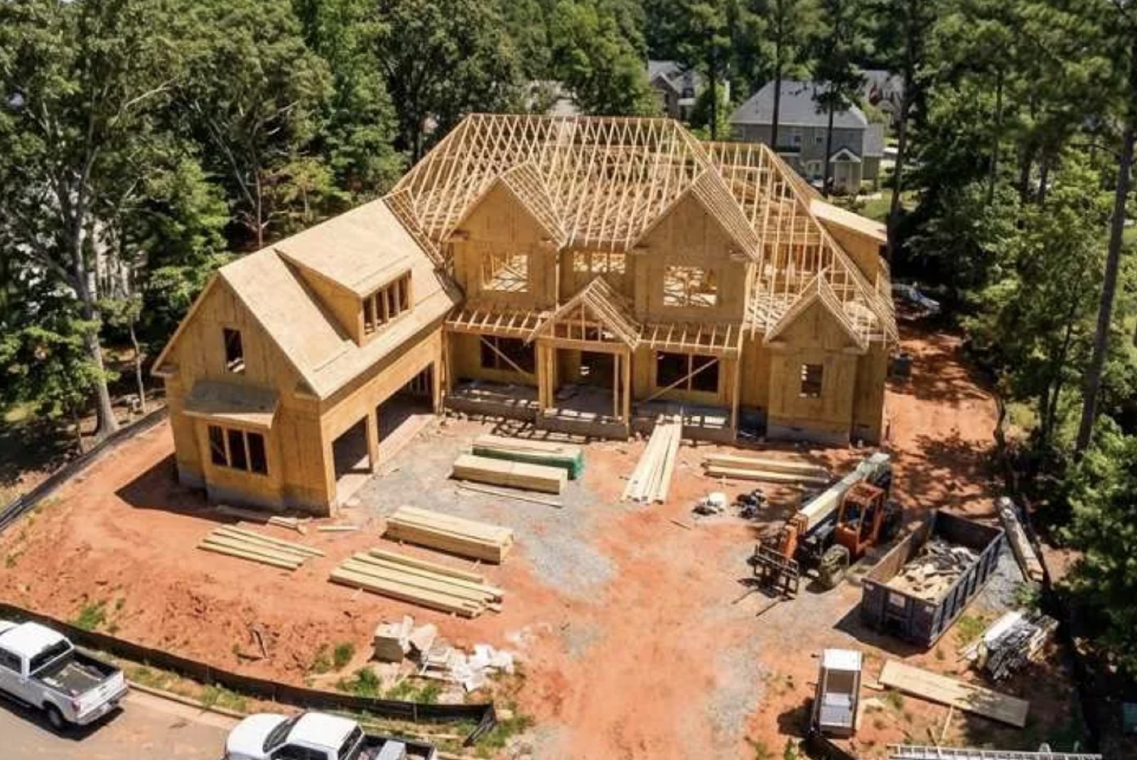 Aerial view of custom two-story home under framing with full roof trusses set
