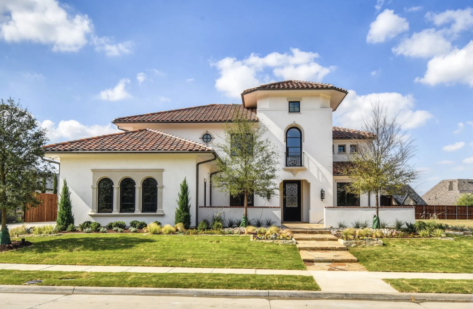 Completed two-story Mediterranean-style custom home with tile roof and stucco facade